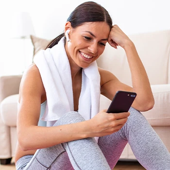 A woman smiling while holding her phone