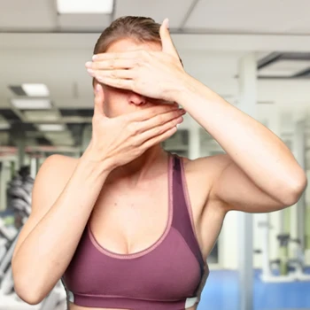 A fit woman covering her eyes and mouth