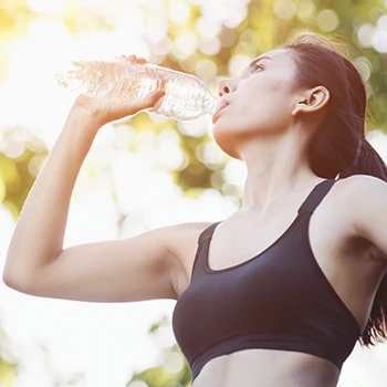 Woman drinking a beverage while sweating
