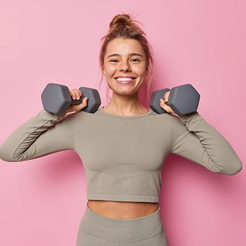 Motivated woman holding dumb bells