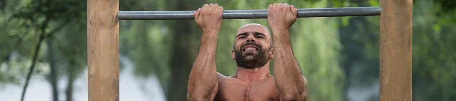 A bald man doing pull ups