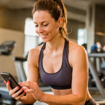 Woman holding phone while working out