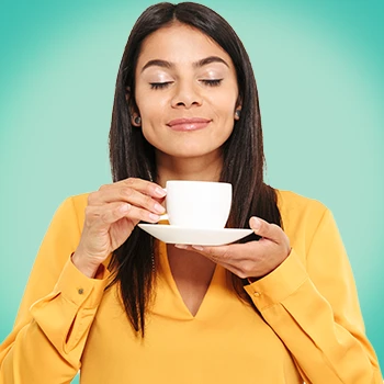 A woman sniffing her hot drink