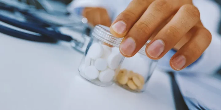 man placing bottles of supplements on table