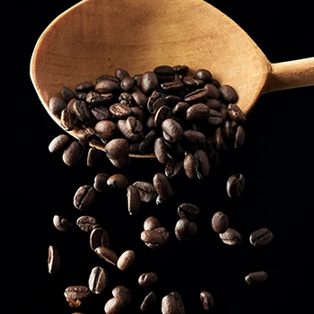 Coffee beans falling from a spoon