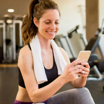 Woman buying supplement online using her phone after workout