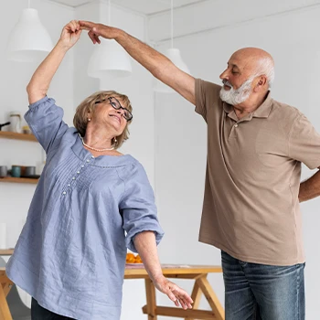 Old couple dancing inside their home