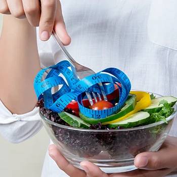 A healthy bowl of meal and measuring tape