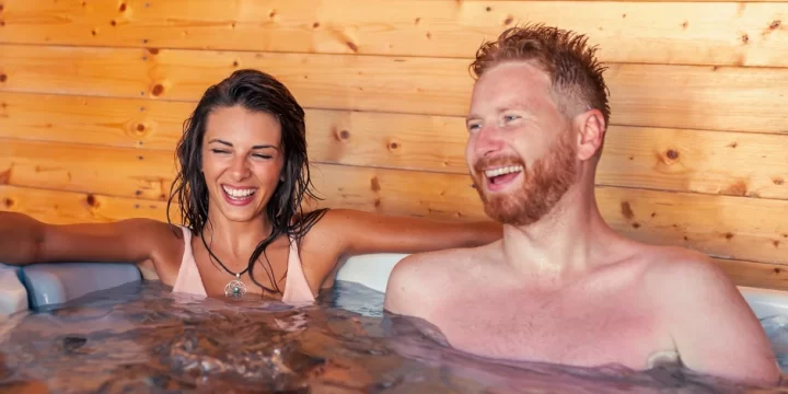 Happy couple sitting in hot tub