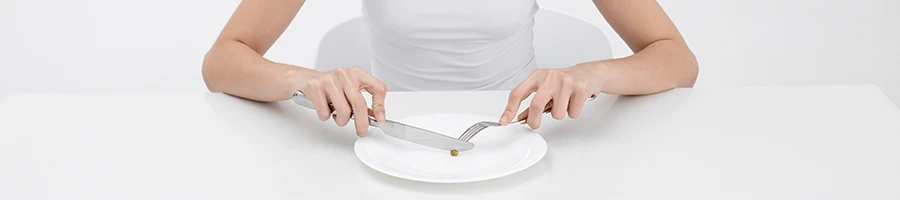 A person eating a small food on a plate