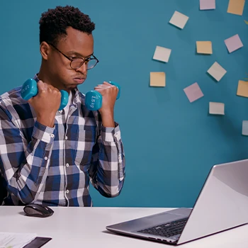 A man holding two light dumbbells at work