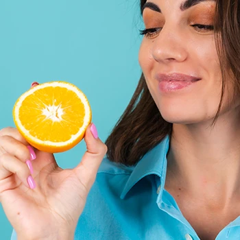 A woman holding an orange