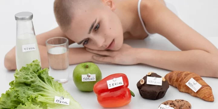 A woman staring at foods with calorie labels