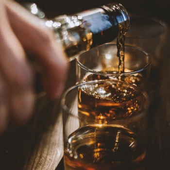 A person pouring alcohol into a glass