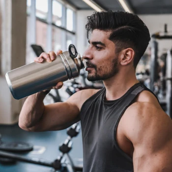 A man holding a shaker bottle in the gym
