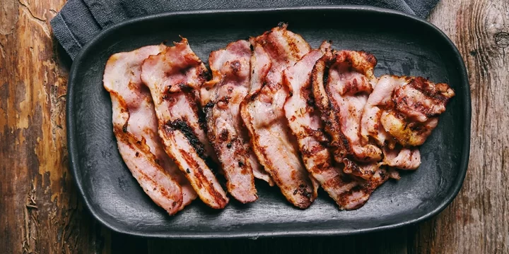 Top view of bacon on black plate