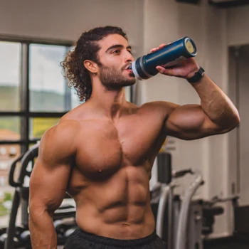 A topless man drinking a pre-workout