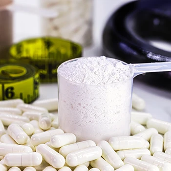 A scoop of mass gainer surrounded by pills