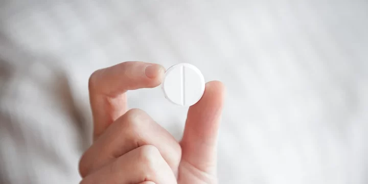 Holding a single white pill