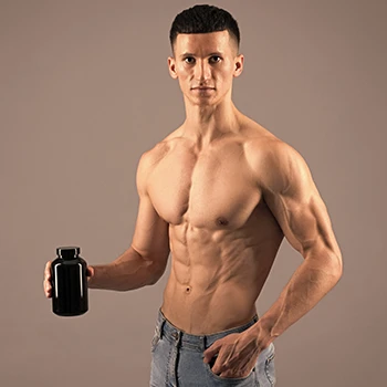 A muscular person holding a mass gainer supplement container