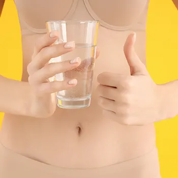 Woman showing her belly while holding water