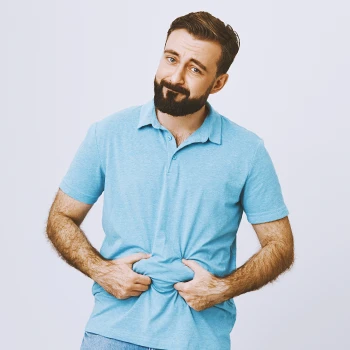 A person in a blue shirt holding his belly