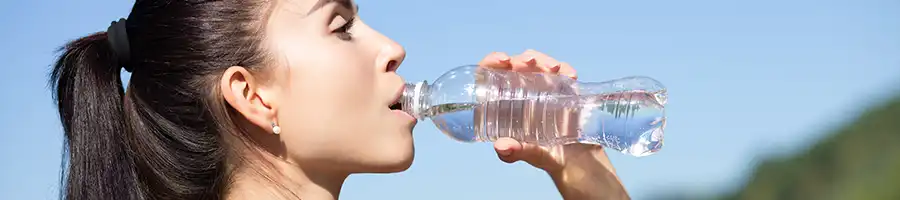 Woman drinking water outdoors