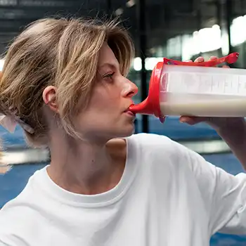 A woman drinking supplement drink