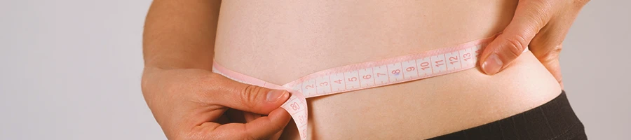 Close up shot of a person measuring her waist