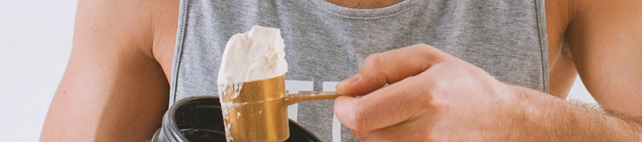 Close up shot of a person scooping protein powder