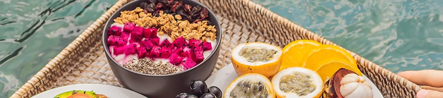 Oatmeal and fruits in a tray floating on a pool