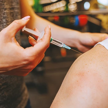 A person injecting steroids into someone's biceps