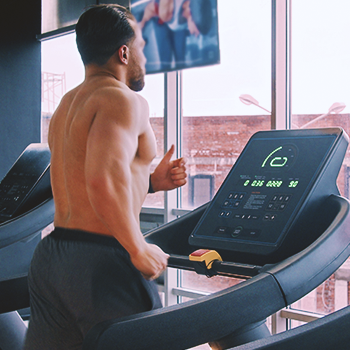 A person running on an inclined treadmill in the gym