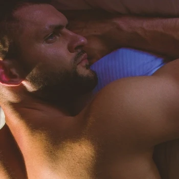 A man using steroids lying down on the bed