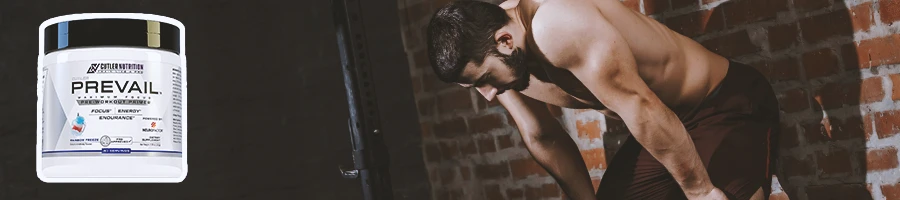 A person in the gym leaning on a wall with Prevail Pre-workout in the foreground