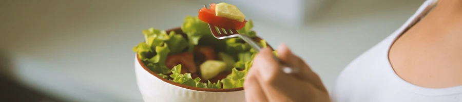 Close up shot of a person eating a salad bowl