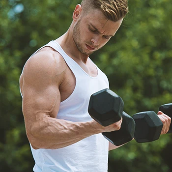 A buff male lifting a dumbbell outside