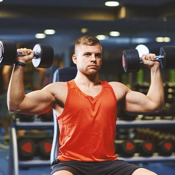 A buff male lifting weights in the gym