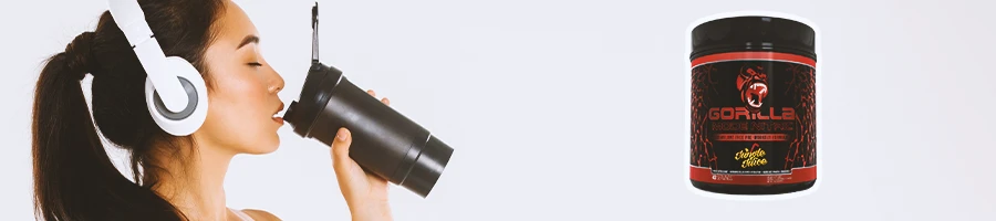 A woman drinking from a tumbler with Gorilla Mode Nitric in the foreground