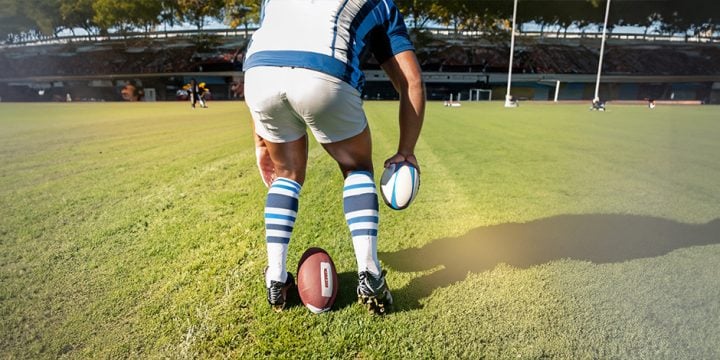 A male rugby player standing in the middle of the field