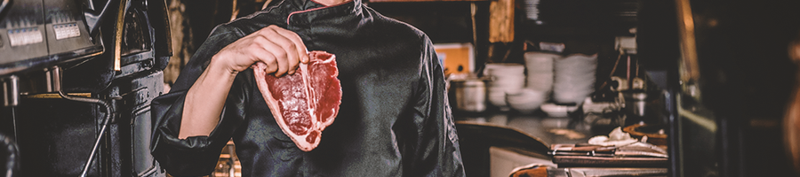 A chef holding up a steak