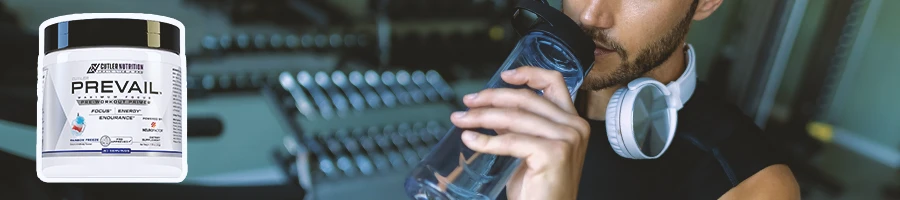 A person drinking in the gym with Prevail Pre-workout in the foreground