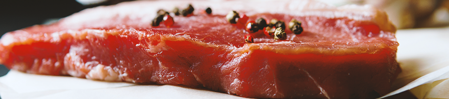 Close up shot of beef steak seasoned with salt and pepper