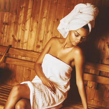 A woman in a sauna sitting down