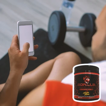 A person looking at his phone in the gym with gorilla mode nitric in the foreground