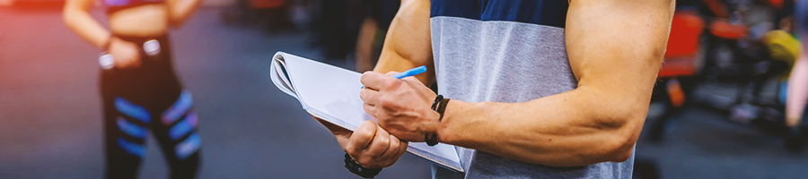 A buff gym coach taking down notes