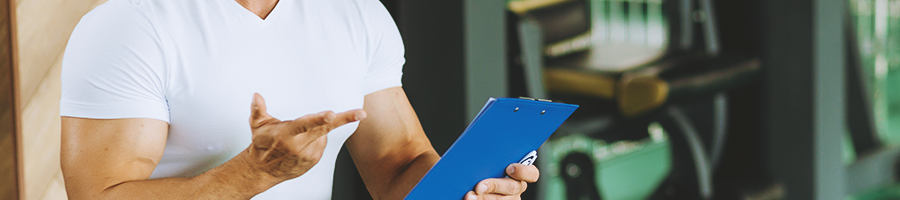 A buff person holding a clip board in the gym