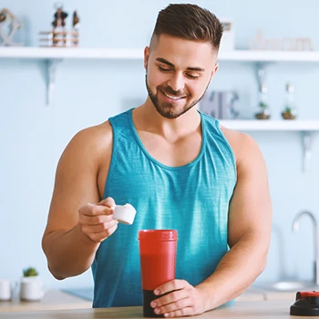 A muscular person mixing powder into a bottle