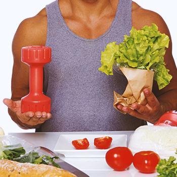 A buff male holding a dumbbell and vegetables