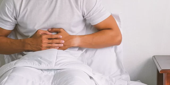 A man with a stomach ache in bed